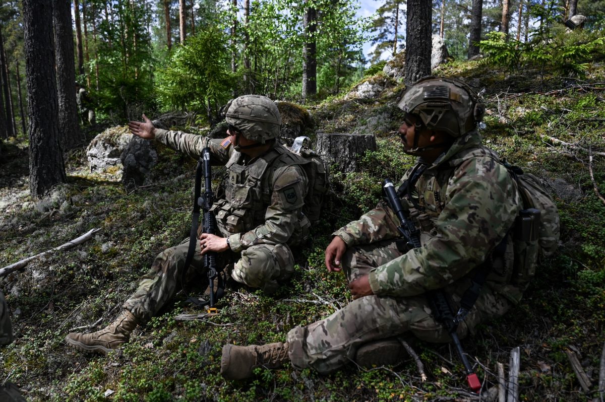 Soldiers seated in forest terrain during field training
